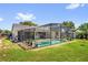 This outdoor pool is screened-in, and is surrounded by a lush green lawn at 5575 Garden Grove Cir, Winter Park, FL 32792