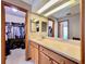 Bathroom vanity with spacious countertop, wood cabinets, and large mirror, next to walk-in closet, offers ample storage at 5724 Pitch Pine Dr, Orlando, FL 32819
