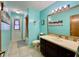 Updated bathroom with a beachy vibe features a vanity, mirror, tiled shower, and door to the outside at 5724 Pitch Pine Dr, Orlando, FL 32819
