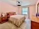 Cozy bedroom with a light pink walls, wood furniture, and large window view at 5724 Pitch Pine Dr, Orlando, FL 32819