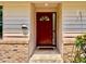 Inviting entryway featuring a red front door, tiled steps, and brick accents at 5724 Pitch Pine Dr, Orlando, FL 32819