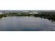 Scenic aerial view of a tranquil lake surrounded by lush green trees and a distant cityscape at 5724 Pitch Pine Dr, Orlando, FL 32819