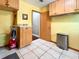 Bright laundry room with tan tile, storage cabinets and countertop with adjacent door to what appears to be the garage at 5724 Pitch Pine Dr, Orlando, FL 32819