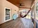Inviting screened patio with ceiling fan, wood flooring, and a relaxing hammock at 5724 Pitch Pine Dr, Orlando, FL 32819