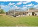 A spacious, grassy backyard featuring a large screened-in pool enclosure at 603 S Sweetwater Blvd, Longwood, FL 32779