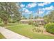 Inviting single-story home with lush lawn and landscaped garden, featuring an American flag at 603 S Sweetwater Blvd, Longwood, FL 32779