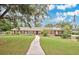 Charming single-story home features a well-manicured lawn and a welcoming front entrance with an American flag at 603 S Sweetwater Blvd, Longwood, FL 32779