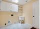 Laundry room features white cabinets and shelves, utility sink, and beige tile flooring at 603 S Sweetwater Blvd, Longwood, FL 32779
