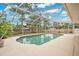 Screened-in pool area with patio and view of the manicured yard, blue sky, and surrounding trees at 603 S Sweetwater Blvd, Longwood, FL 32779