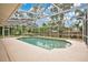 Screened-in pool area with sunny patio and view of the blue sky and surrounding trees at 603 S Sweetwater Blvd, Longwood, FL 32779