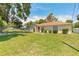 Well-maintained home with a spacious front yard, a red front door, and shuttered windows at 620 Unabelle Ave, Holly Hill, FL 32117