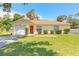 Charming single-story home with well-maintained lawn, red door, and attached garage at 620 Unabelle Ave, Holly Hill, FL 32117