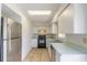 Functional kitchen with white cabinets, tile flooring, and stainless steel appliances at 620 Unabelle Ave, Holly Hill, FL 32117