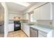 Kitchen featuring white cabinets, tile flooring, and practical appliances at 620 Unabelle Ave, Holly Hill, FL 32117