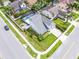 Aerial view of a well-manicured property featuring a gray home, a screened pool, and a lush green lawn at 754 Birgham Pl, Lake Mary, FL 32746