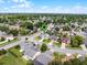 Aerial view featuring a home with surrounding neighborhood, lush greenery, and a serene lake in the distance at 754 Birgham Pl, Lake Mary, FL 32746