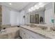 Well-lit bathroom featuring double sinks, granite countertops, and a tub with a window at 754 Birgham Pl, Lake Mary, FL 32746
