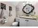 Charming half bath with granite countertop, decorative mirror, and stylish fixtures at 754 Birgham Pl, Lake Mary, FL 32746