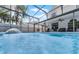 A large, screened-in pool with a built-in fountain feature, surrounded by outdoor seating, and a clear blue sky at 754 Birgham Pl, Lake Mary, FL 32746