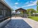 View of the brick paved backyard featuring a gazebo and a screened-in patio at 7911 Murcott Cir, Orlando, FL 32835