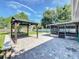A spacious brick paved backyard, featuring a gazebo, a screened-in patio, and a well-maintained lawn at 7911 Murcott Cir, Orlando, FL 32835