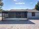 Backyard featuring a brick paved section, a screened-in patio, and lush green trees at 7911 Murcott Cir, Orlando, FL 32835