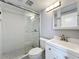 Updated bathroom featuring a glass shower door, hexagon tile and white vanity at 7911 Murcott Cir, Orlando, FL 32835