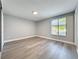 Bedroom featuring wood-look floors, a window with blinds, and neutral paint at 7911 Murcott Cir, Orlando, FL 32835