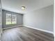 Bright bedroom featuring wood-look floors, a window with blinds, and neutral paint at 7911 Murcott Cir, Orlando, FL 32835