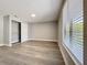 Bedroom featuring wood-look floors, a window with blinds, and a closet at 7911 Murcott Cir, Orlando, FL 32835