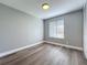 Bedroom features wood-look floors, a window with blinds, and neutral paint at 7911 Murcott Cir, Orlando, FL 32835