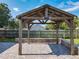 A wooden gazebo sits on a brick paver patio with a low block wall, adding charm to the backyard space at 7911 Murcott Cir, Orlando, FL 32835