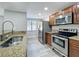 Galley kitchen featuring stainless appliances, granite counters, and wood-look laminate flooring at 7911 Murcott Cir, Orlando, FL 32835