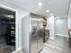 Kitchen area with stainless steel refrigerator, and dark-colored wood cabinetry, plus a view into an attached garage at 7911 Murcott Cir, Orlando, FL 32835
