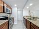 Stylish kitchen with stainless steel appliances, granite countertops, and wood-look laminate floors at 7911 Murcott Cir, Orlando, FL 32835