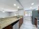 View of the kitchen's breakfast bar, looking into the living room and laundry area with window at 7911 Murcott Cir, Orlando, FL 32835