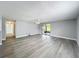 Spacious living room with light wood floors, ceiling fan, and sliding door access to outdoor space at 7911 Murcott Cir, Orlando, FL 32835