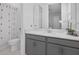 Contemporary bathroom with white vanity, quartz countertop, decorative mirror and modern shower with a patterned shower curtain at 8080 Peaceful Cir, Sanford, FL 32771