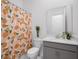 Well-lit bathroom with a patterned shower curtain, toilet, and plants at 8080 Peaceful Cir, Sanford, FL 32771