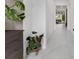 Bright hallway featuring white tile flooring and neutral walls, leading to a living area at 8080 Peaceful Cir, Sanford, FL 32771