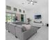Bright and airy living room with high ceilings, large windows, and a comfortable gray sectional sofa at 8080 Peaceful Cir, Sanford, FL 32771