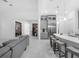 Open-concept living area with white marble floors, modern kitchen, and comfortable gray sofa at 8080 Peaceful Cir, Sanford, FL 32771