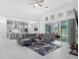Bright living room features a gray sectional sofa, open access to the kitchen, and sliding glass doors to outdoor patio at 8080 Peaceful Cir, Sanford, FL 32771