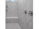 Detailed view of a modern shower featuring marble tiling, a built-in bench, and sleek fixtures at 8080 Peaceful Cir, Sanford, FL 32771