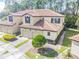 Aerial view of villa showing brick driveway, two-car garage, and manicured landscaping at 8219 Roseville Blvd, Davenport, FL 33896