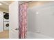 Bathroom with shower, tub and stacked washer and dryer at 8219 Roseville Blvd, Davenport, FL 33896