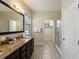 Modern bathroom with glass shower, vanity, large mirror and view into the walk-in closet at 8219 Roseville Blvd, Davenport, FL 33896