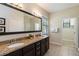 Modern bathroom featuring granite countertops, a double vanity, and a large mirror at 8219 Roseville Blvd, Davenport, FL 33896