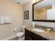Well-lit bathroom featuring granite counters, a toilet, and a shower/tub combo at 8219 Roseville Blvd, Davenport, FL 33896