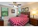 Bright bedroom with a ceiling fan, two windows and a plush bed with matching headboard at 8219 Roseville Blvd, Davenport, FL 33896